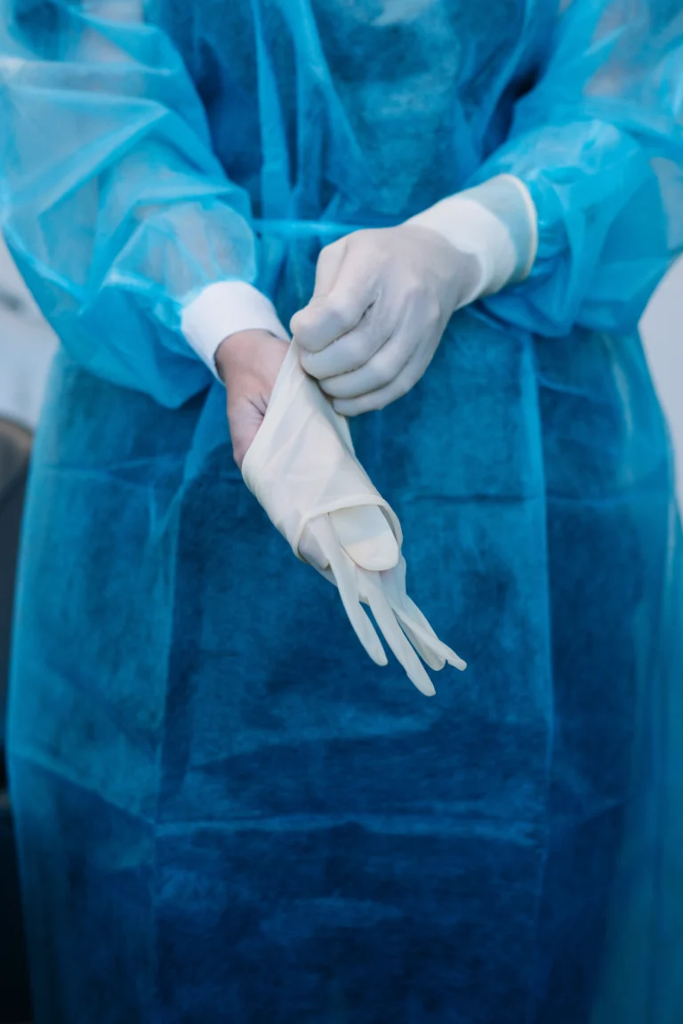 Clinician putting on sterile surgical gloves