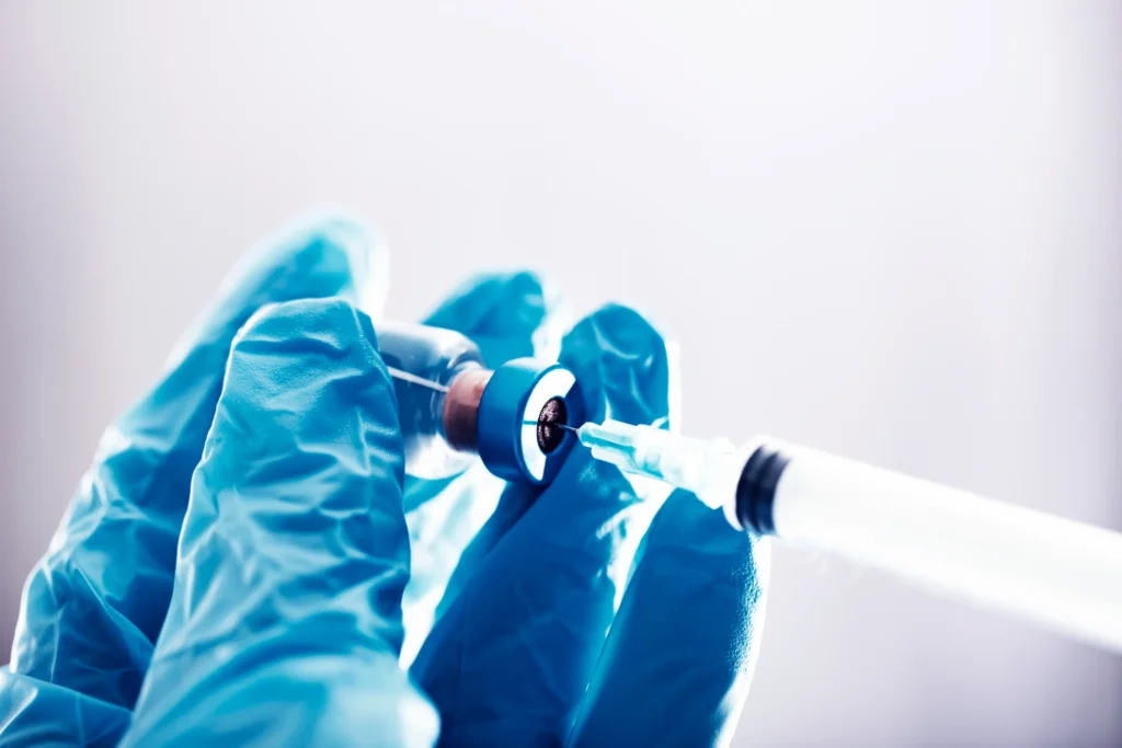 Gloved hands preparing a local anaesthetic injection