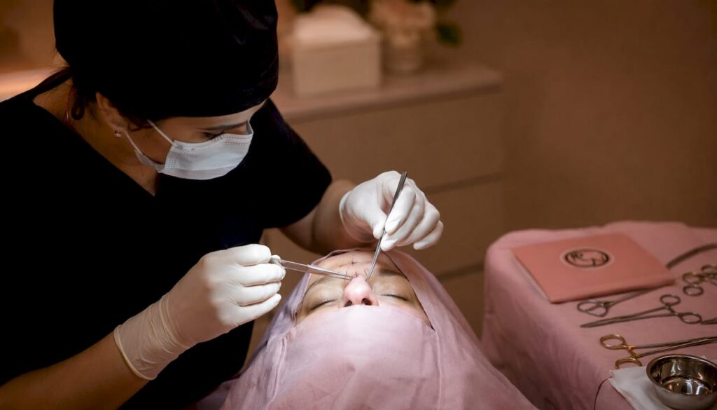 A surgeon suturing a local flap during facial reconstruction